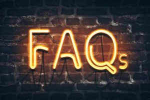 FAQs neon sign on dark brick wall background